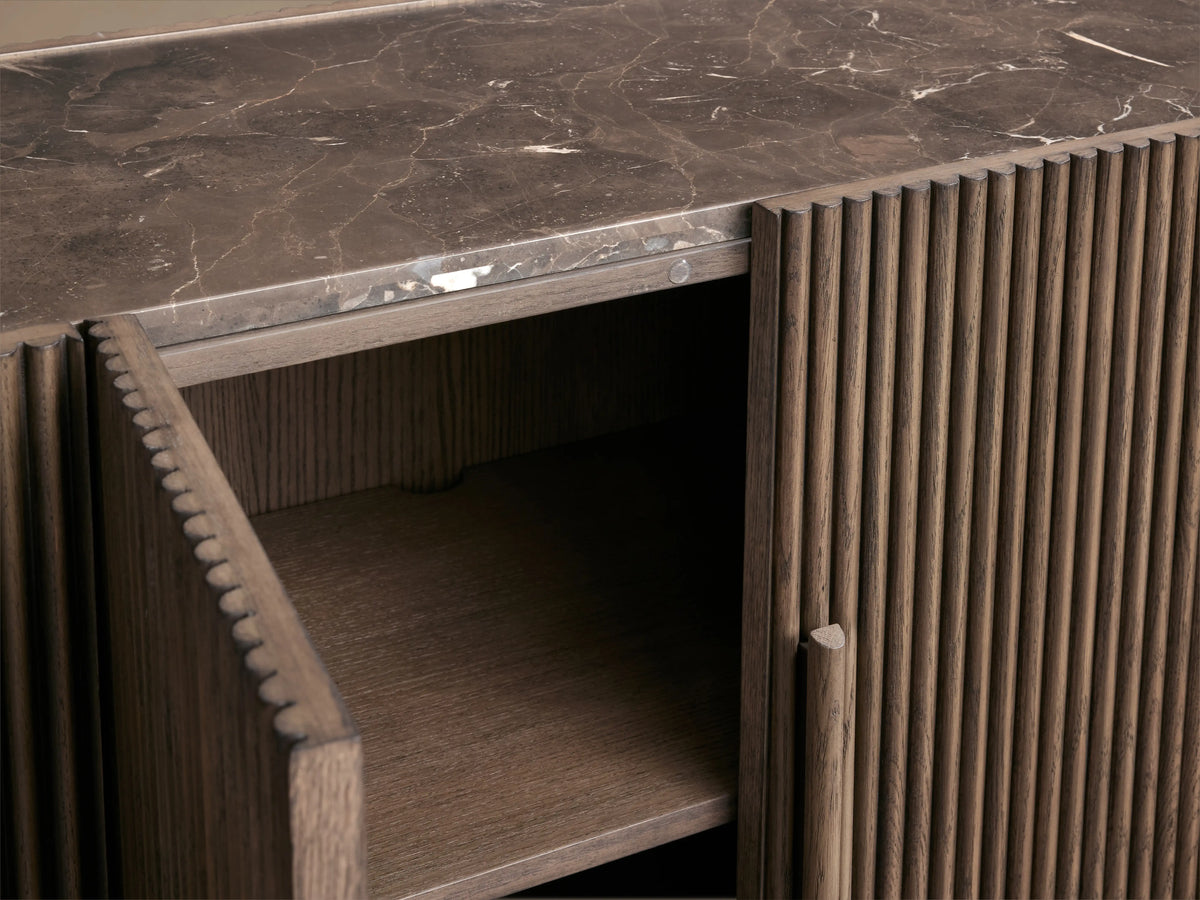 Astor Sideboard with oak veneer finish, solid oak reeding, natural marble top, and a partially open soft-close door revealing shelves.