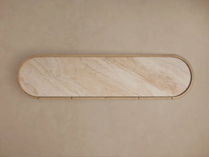 Close-up of Astor Sideboard: light oak reeded door, beige marble top, open to show a book and gold decor inside.