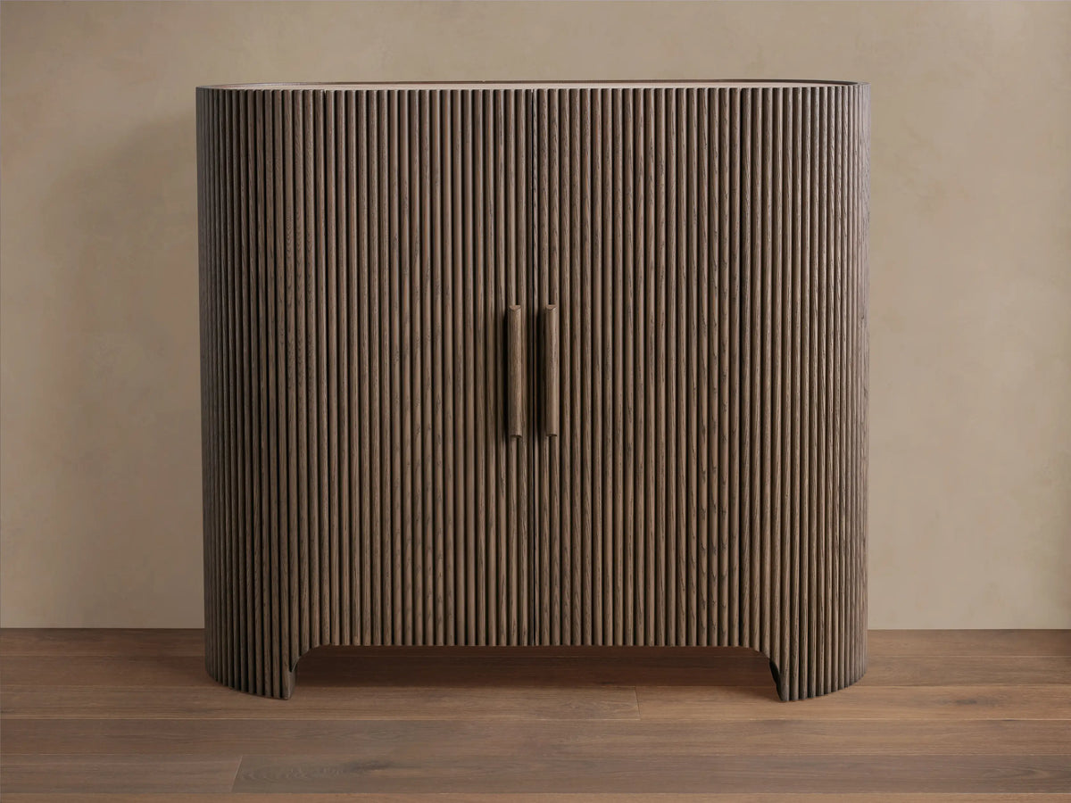 Astor Hall Chest: Dark brown, reeded oak veneer cabinet with curved sides, two doors, and wooden pulls on a wood floor.