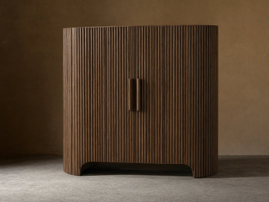 Astor Hall Chest: Dark brown, reeded oak veneer cabinet with curved sides, two doors, and wooden pulls on a wood floor.