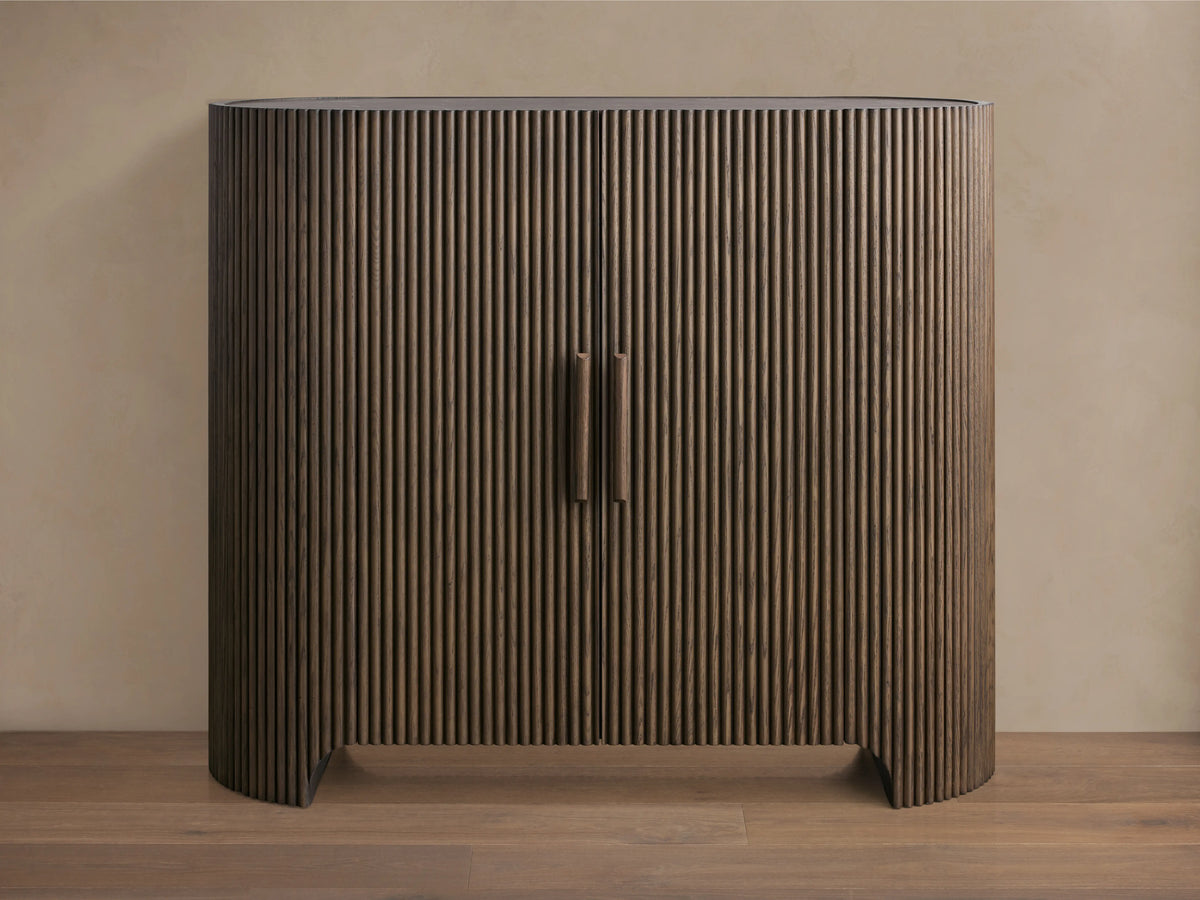 Astor Hall Chest with vertical oak wood reeding, two central soft-close doors, and inset marble top on wooden floor.