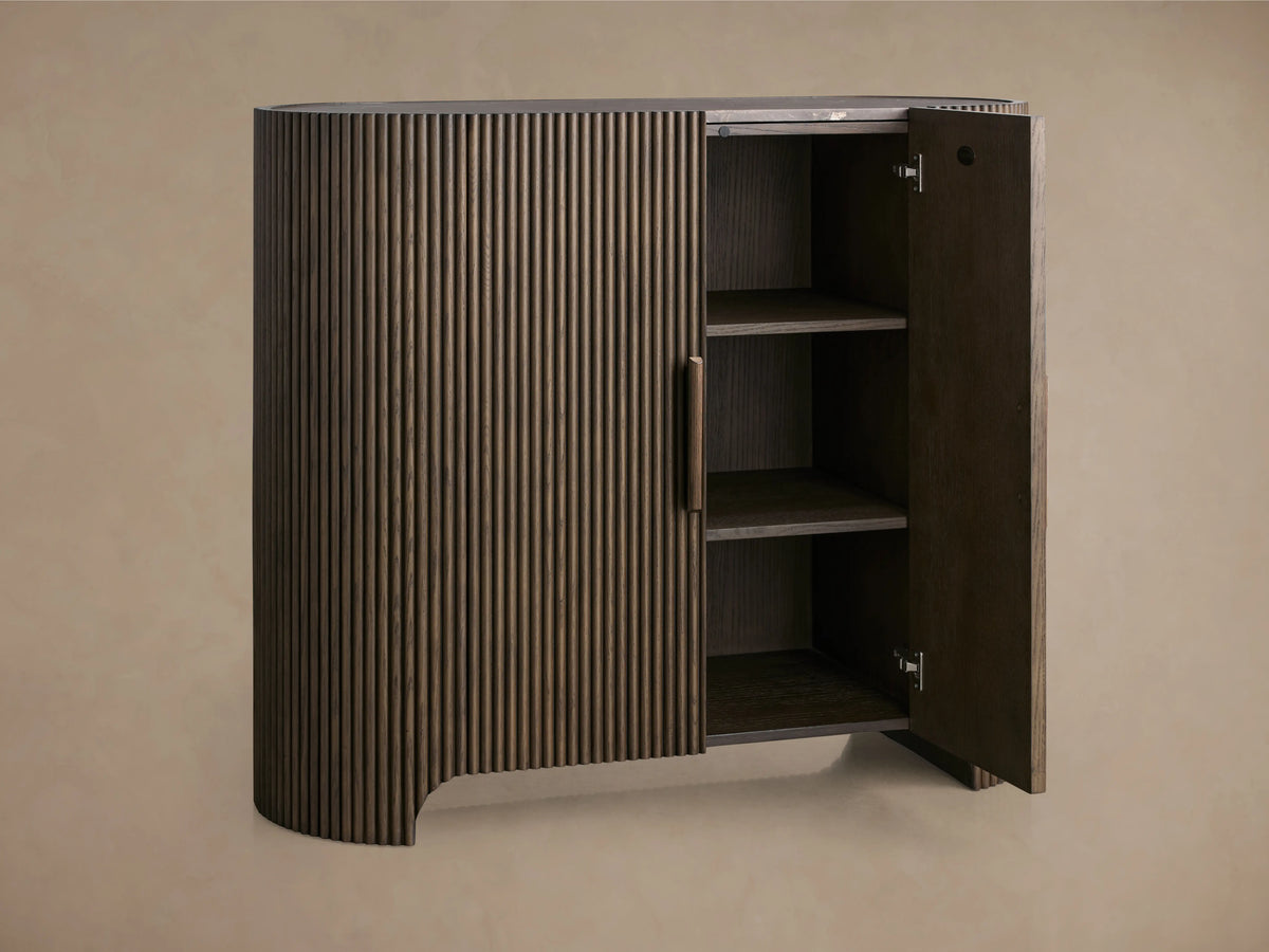 Astor Hall Chest made of oak veneers with vertical reeding, open wood cabinet door showing shelves, subtle brass accent.