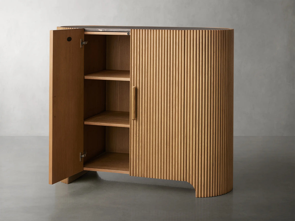 Astor Hall Chest with vertical oak wood reeding, soft-close doors, and wooden pulls on a gray background.