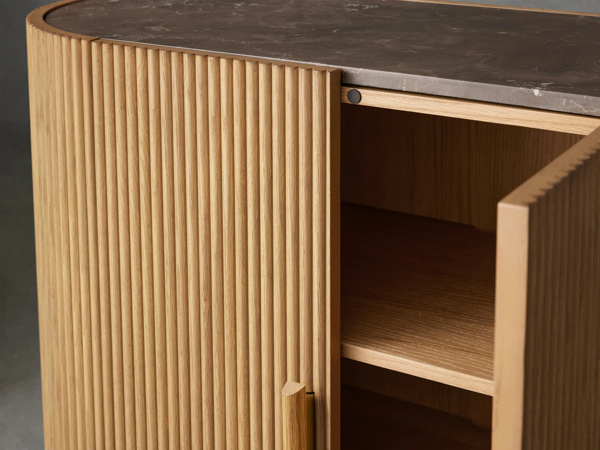 Astor Hall Chest featuring oak reeding details, open soft-close door showing shelves, with brass-accented wooden pull, and marble top.