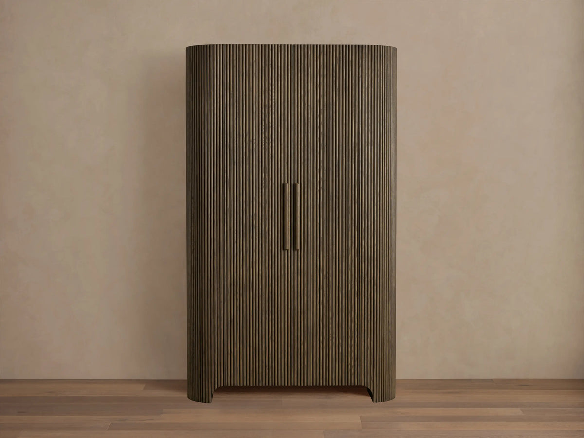 Front view of the dark oak Astor Cabinet with vertical reeding, rounded sides, and two vertical wooden pulls.
