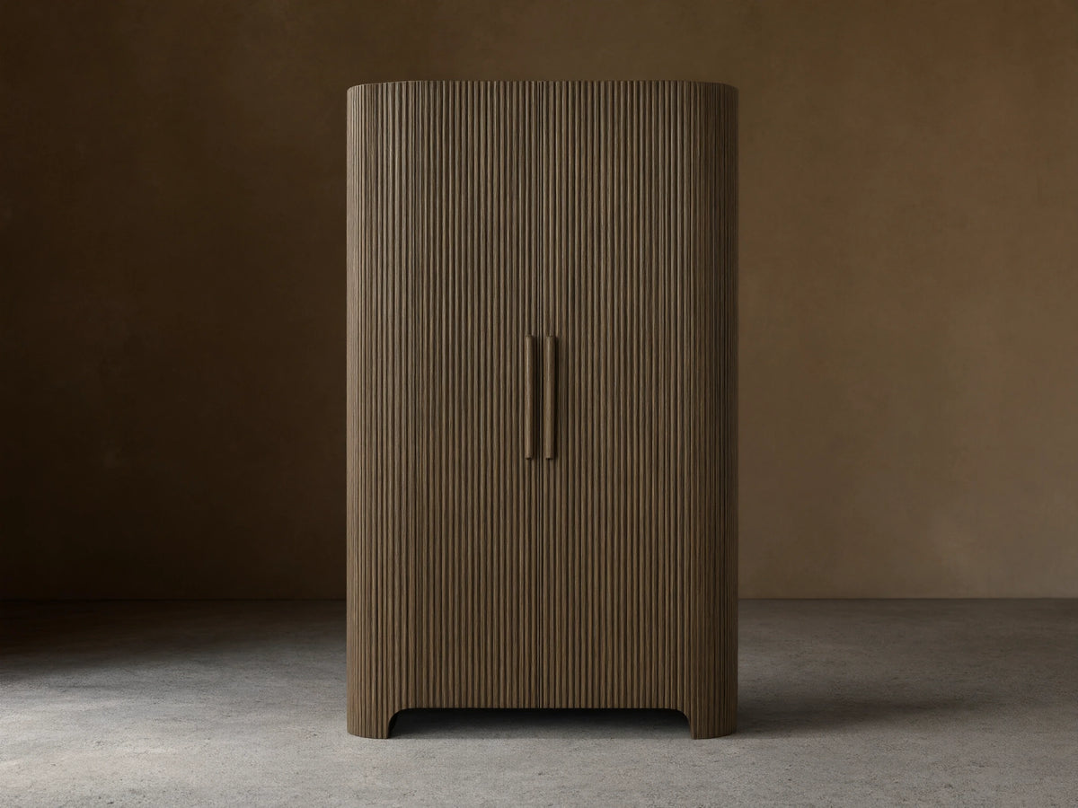 Front view of the dark oak Astor Cabinet with vertical reeding, rounded sides, and two vertical wooden pulls.