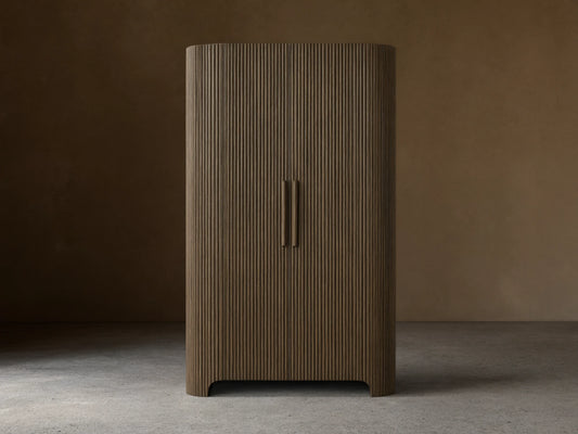 Front view of the dark oak Astor Cabinet with vertical reeding, rounded sides, and two vertical wooden pulls.