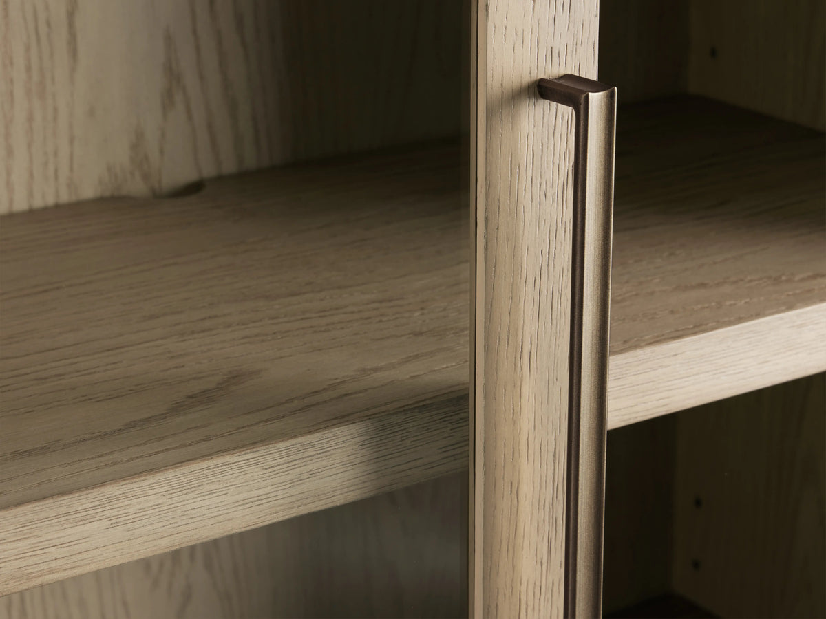 Close-up of Bodhi Cabinet showing solid white oak veneer with subtle grain patterns, brass handle, and two adjustable shelves.