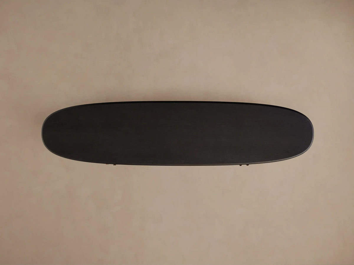 Dark, oval Bexler Sideboard, top-down view, showcasing its Abanos finish on a neutral background.