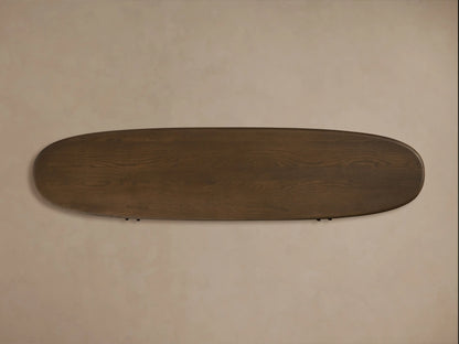Top view of a dark brown, oval-shaped Bexler Sideboard with visible wood grain, set against a light beige wall.