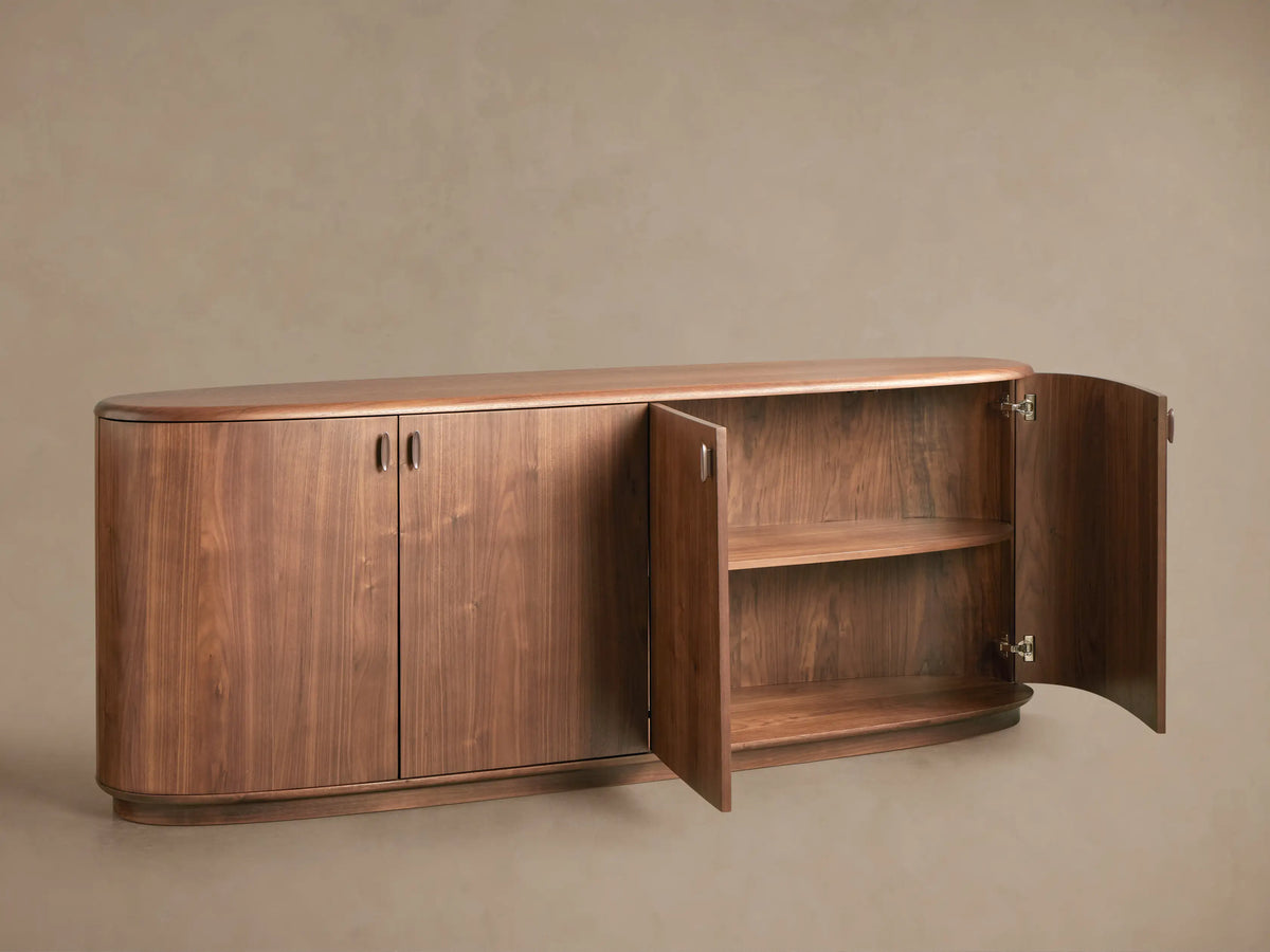 Curved, walnut-finished Bexler Sideboard. Two central doors closed, right door open revealing two interior shelves.