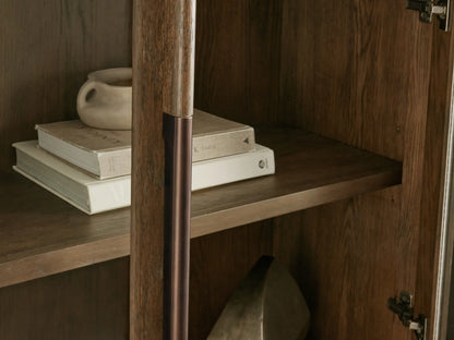 Bardot Cabinet close-up: dark stained white oak interior shelf with stacked books & light mug, bronze wood-aluminum handle.