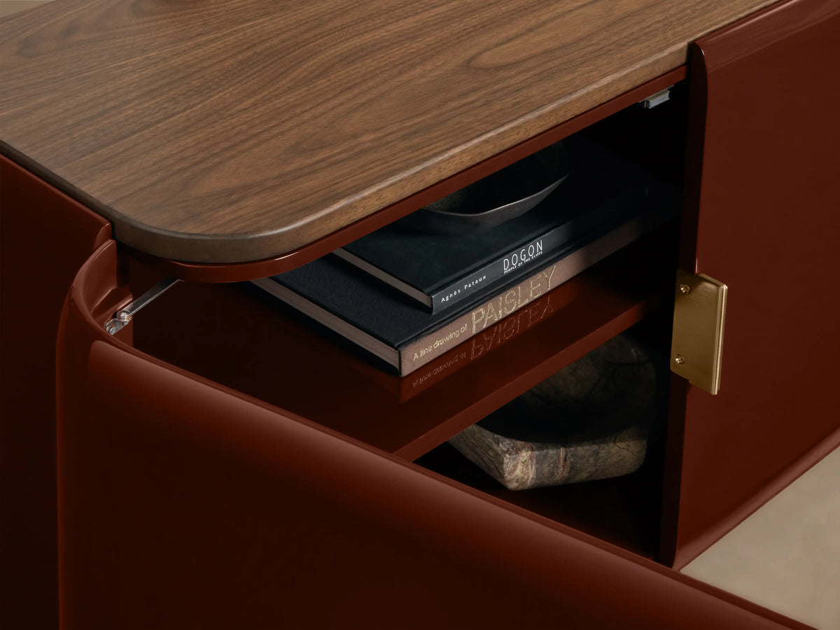 Front view of the Bryer Media Console with oxblood lacquer body and walnut top; two right doors are open revealing interior shelves.