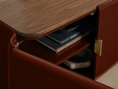 Front view of the Bryer Media Console with oxblood lacquer body and walnut top; two right doors are open revealing interior shelves.