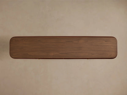 Close-up of the oxblood Bryer Media Console, showing its walnut-finished top and champagne brass hardware.