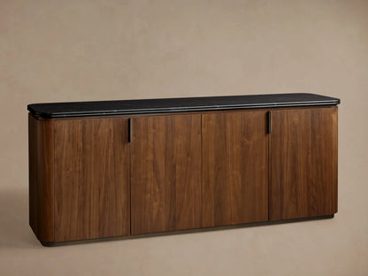 Walnut Caden Sideboard with four doors, antique bronze hardware, and a veined black marble top, on wooden floor.