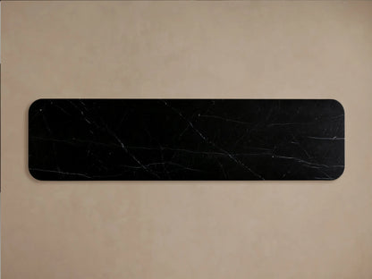 Close-up of Caden Sideboard with a black marble top, curved walnut wood base. A door is ajar, showing clear glasses and bowls inside.