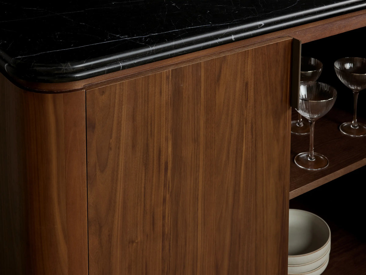 Caden Sideboard with dark Black Marquina marble top, rich walnut wood base, and four doors with antique bronze handles.