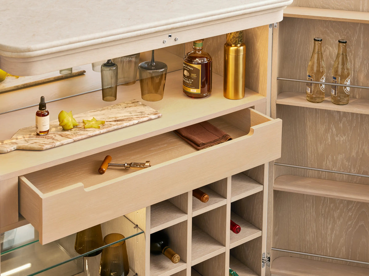Caden Bar Cabinet: Close-up of a light wood interior, illuminated LED strip, and white stemware rack holding dark glasses.