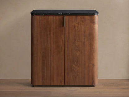 Caden Bar Cabinet with walnut wood veneer, rounded front, black marble top, and subtle vertical pull.