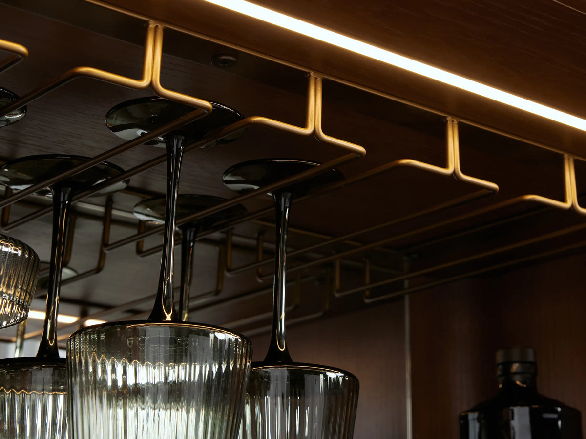 Caden Bar Cabinet with walnut wood veneer, rounded front, black marble top, and subtle vertical pull.