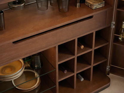 Interior of Caden Bar Cabinet with antique bronze stemware rack, hanging dark glasses, warm LED light, and walnut wood.