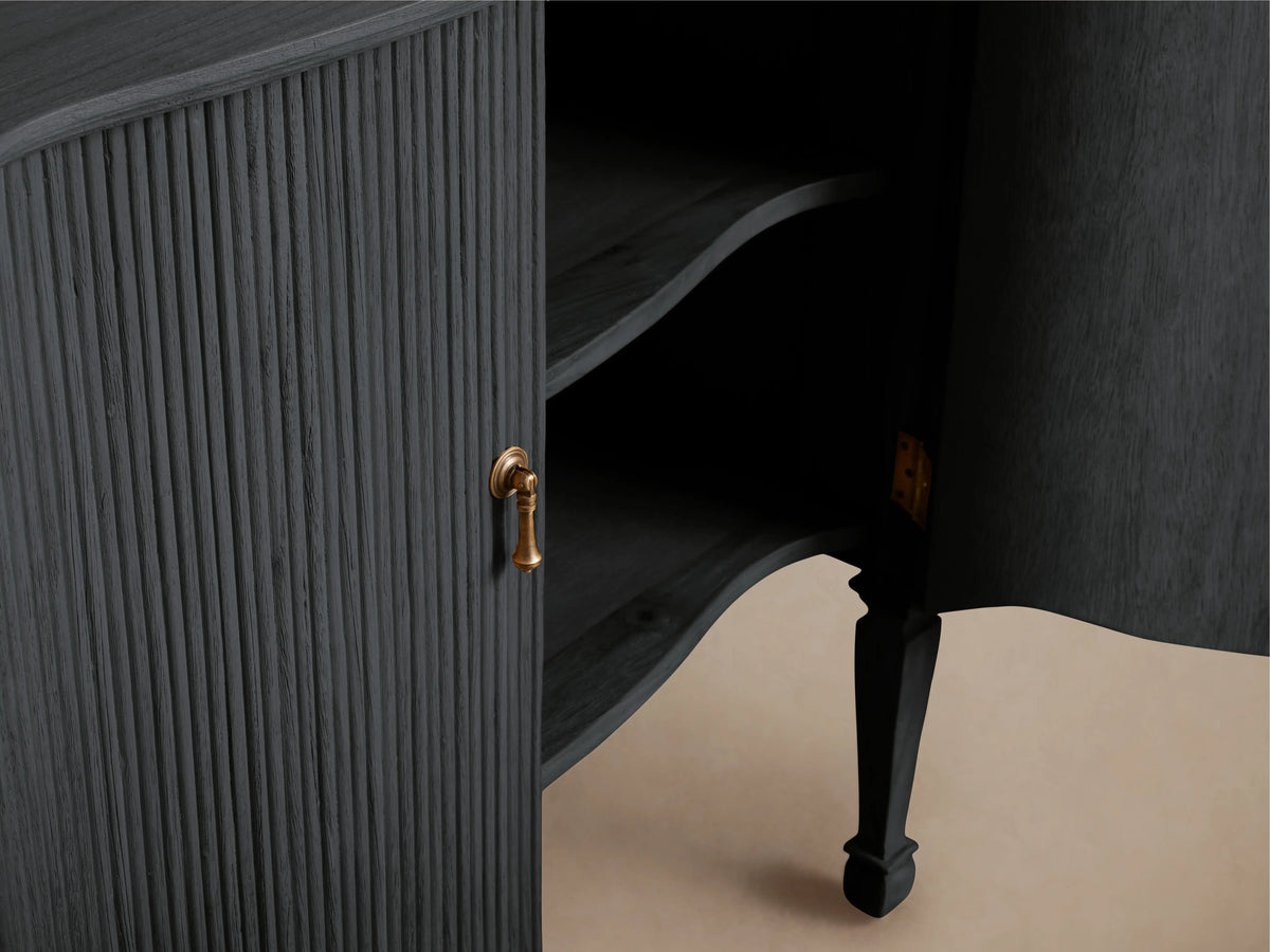 Conrad Hall Chest with ribbed, dark wood finish and open door revealing shelves. Features a gold handle and slender, curved legs.