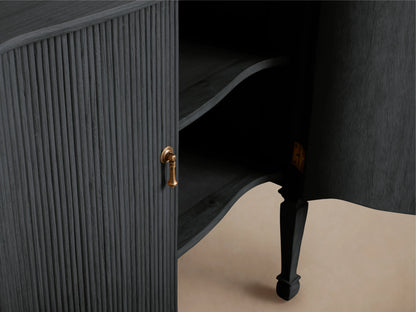 Conrad Hall Chest with ribbed, dark wood finish and open door revealing shelves. Features a gold handle and slender, curved legs.