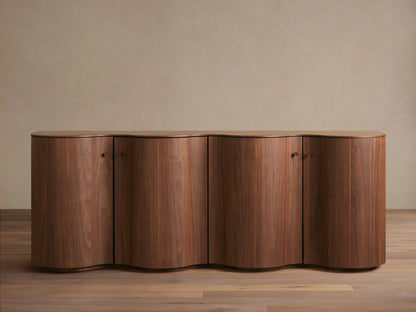 Cortina Sideboard in rich wood finish with curved edges and four cabinet doors, set against a neutral wall on wood flooring.