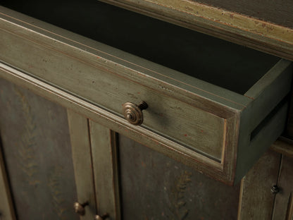 Cosetta Buffet, distressed sage green, hand-painted fern on left door, fluted facade, molded details. Right door open, shelf visible.