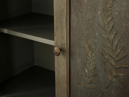 Cosetta Buffet: Distressed sage green wood drawer, partially open, with an aged brass knob, above cabinet doors with faint decor.