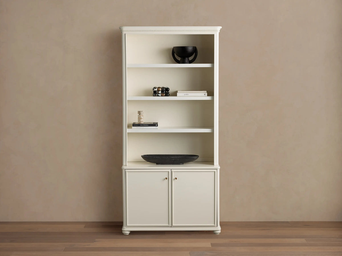 Cream oak Carlisle Hutch with open shelves displaying decor, and two lower cabinet doors, on a light brown wall and wood floor.