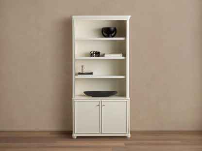 Cream oak Carlisle Hutch with open shelves displaying decor, and two lower cabinet doors, on a light brown wall and wood floor.