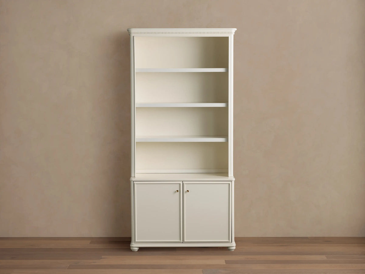 Cream oak Carlisle Hutch with open shelves displaying decor, and two lower cabinet doors, on a light brown wall and wood floor.