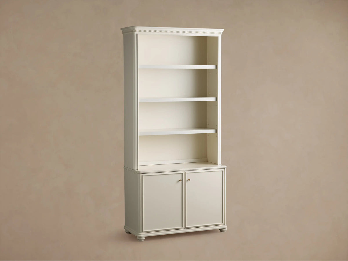Carlisle Hutch: Cream-colored wooden cabinet with open upper shelves, one bottom cabinet door ajar revealing an interior shelf.