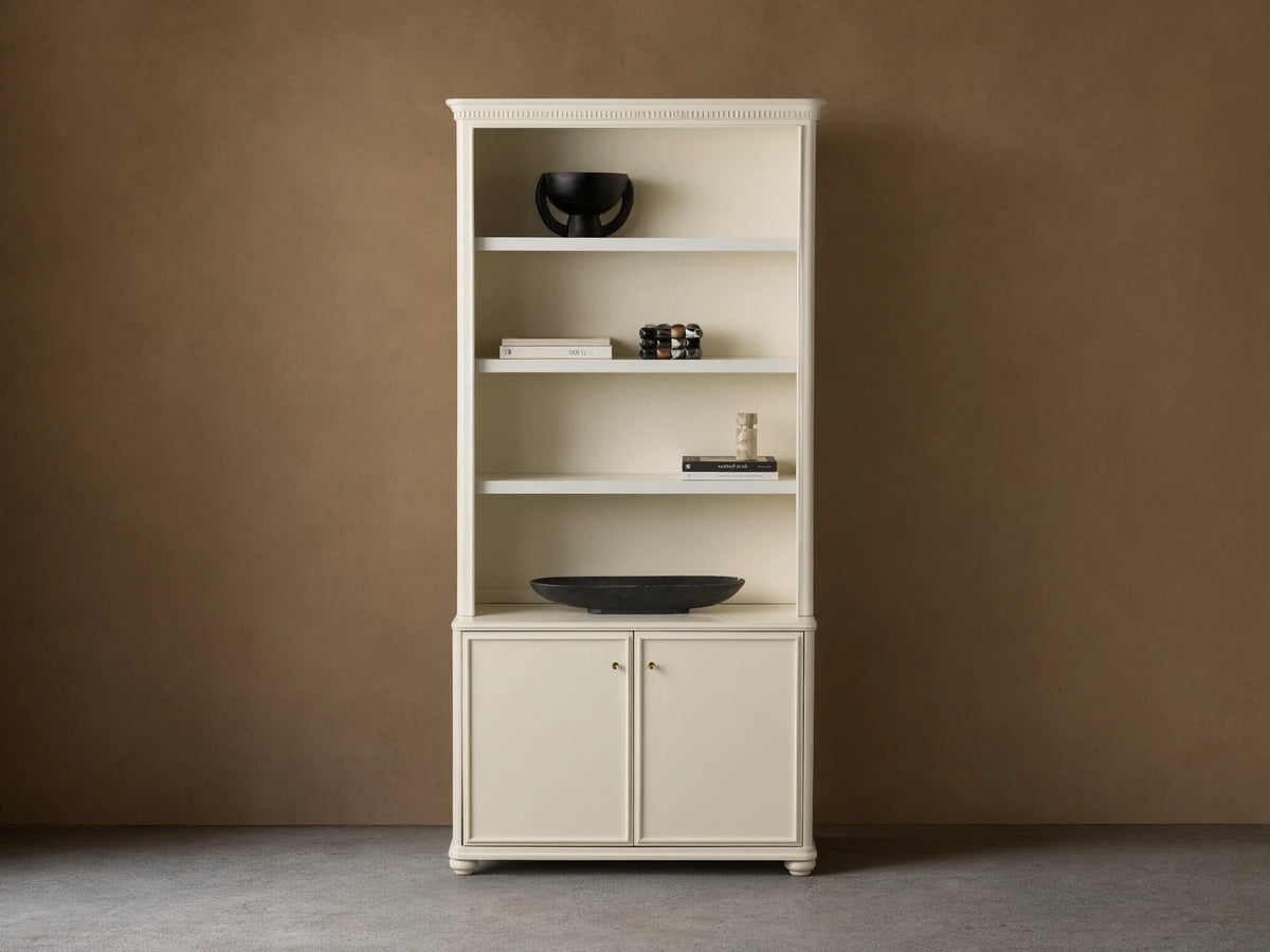 Cream oak Carlisle Hutch with open shelves displaying decor, and two lower cabinet doors, on a light brown wall and wood floor.