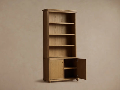 Close-up of Carlisle Hutch's interior, showing light oak shelves styled with stacked books, a white jar, brass cup, and metallic bookend.