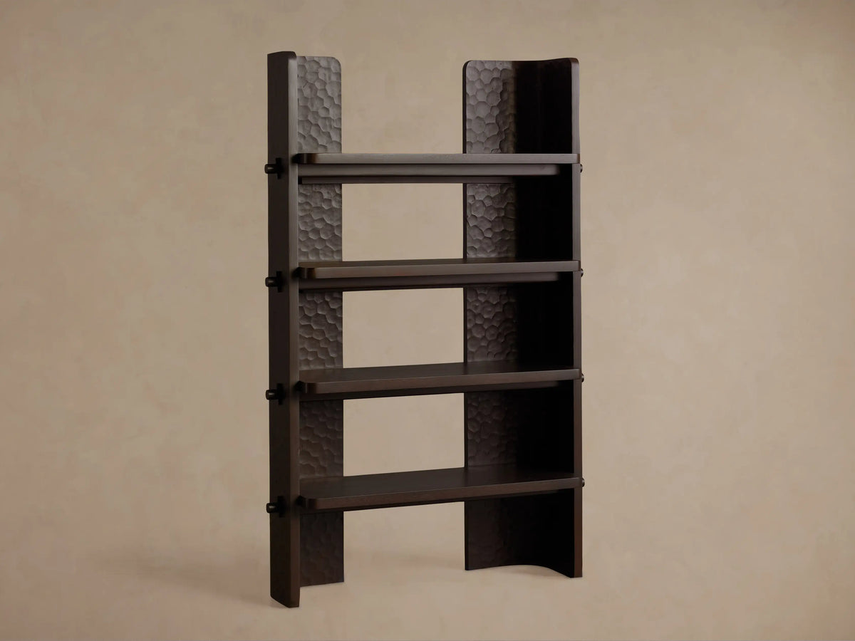 Chiseled Bookcase, dark mahogany wood with carved details. Upper shelf holds a white book, lower has a vase with flowers.