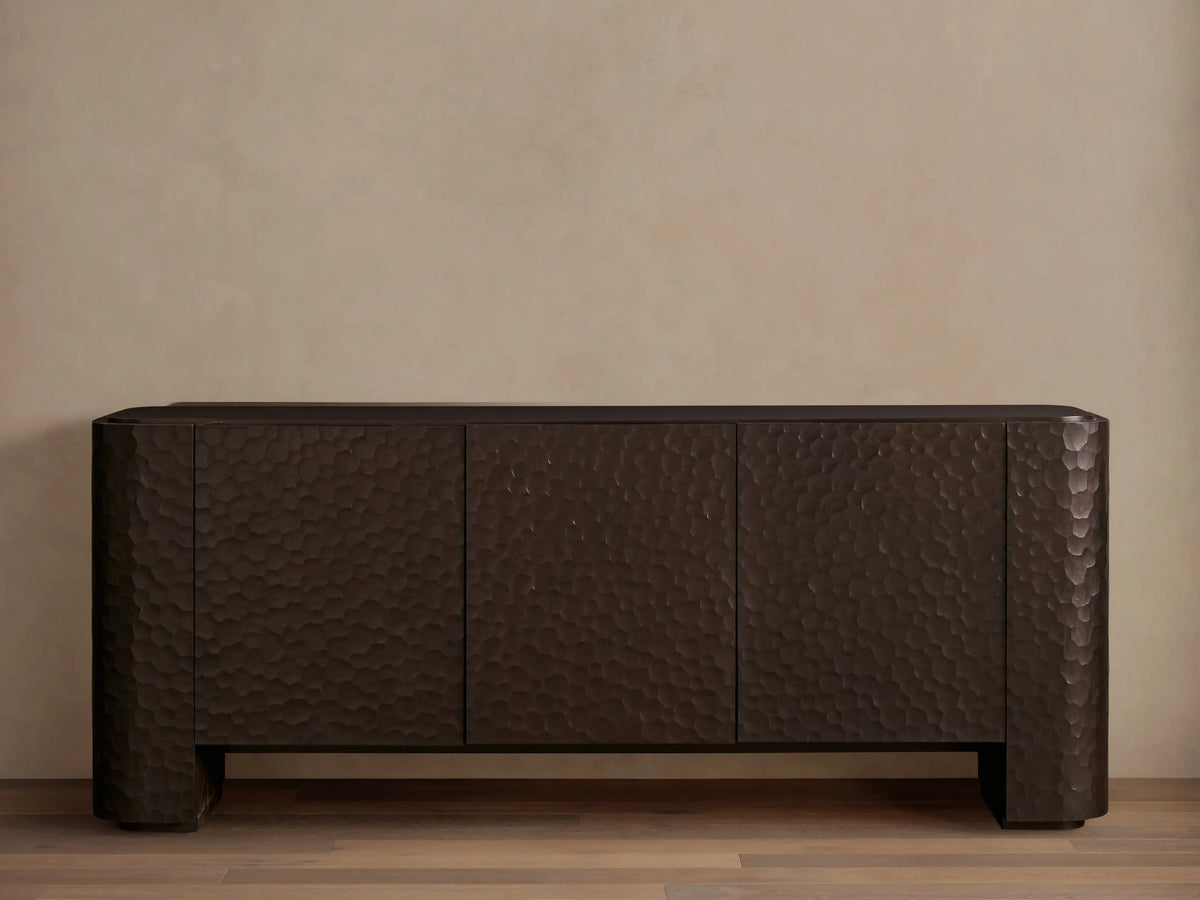 Dark brown Chiseled Sideboard with three textured doors, showcasing carved mahogany and a hand-applied finish on a wooden floor.
