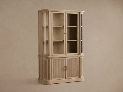 Close-up of Coventry Cabinet in light white oak. Open lower right door shows shelf. Fluted lower left door, antique brass handle.