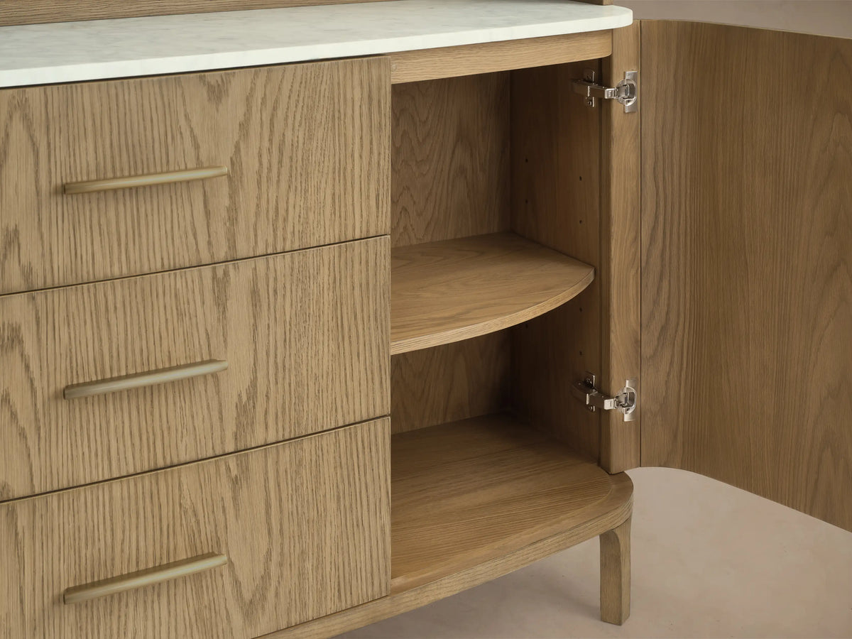 Front view of the light oak wood Danny Hutch with Drawers, featuring an arched top, open shelves, white Carrara marble, and brass handles.