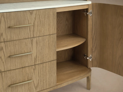 Front view of the light oak wood Danny Hutch with Drawers, featuring an arched top, open shelves, white Carrara marble, and brass handles.