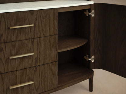 Front view of the dark oak Danny Hutch with Drawers, featuring an arched top, 3 open shelves, a white marble counter, 2 cabinet doors, 3 drawers with brass pulls, and tapered legs.