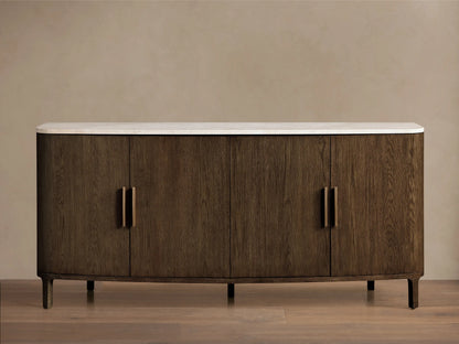 Front view of a dark brown wooden sideboard with a white marble top, curved ends, and four doors featuring gold bar handles.