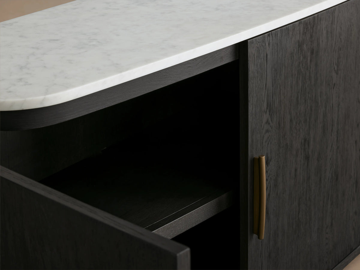 Danny Sideboard in ebony finish with white Carrara marble top, open door showing interior shelf, brass handle visible.