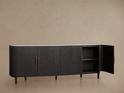 Danny Sideboard with ebony finish, white Carrara marble top. Features brass handles and a partially open door revealing shelves.