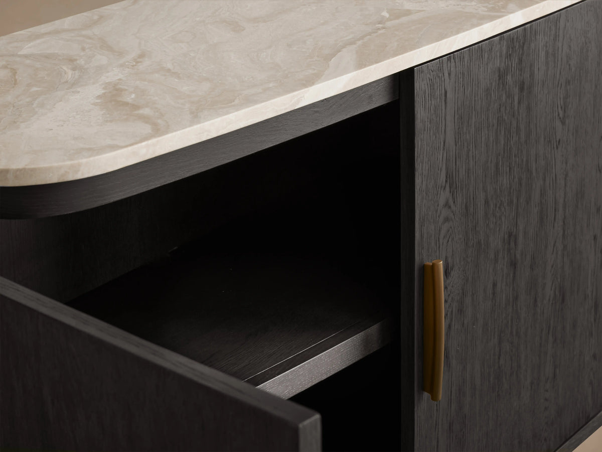 Danny Sideboard with open dark oak cabinet door, brass handle, and light marble top displaying unique veining.