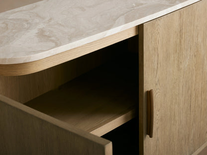 Danny Sideboard with fawn finish, featuring a royal cream marble top. Brass-finished handle on partially open door, revealing a shelf.