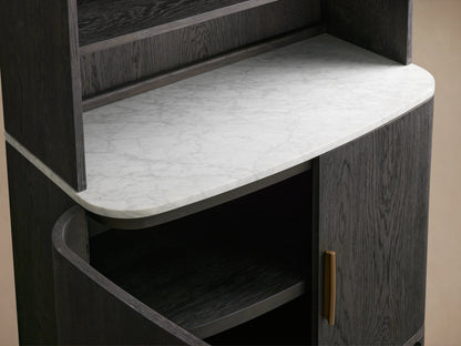 Danny Hutch shown with a dark ebony finish, featuring a white Carrara marble top. It has a gold handle and visible shelves.