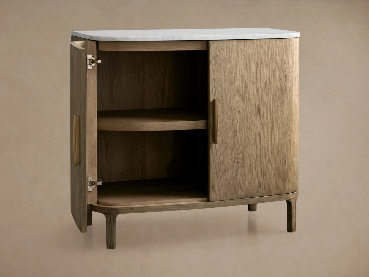 Danny Cabinet in oak with a hand-applied fawn finish, white marble top. Open door reveals interior shelf.